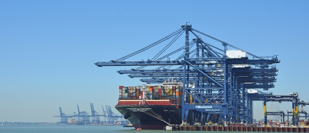 Container vessel berthed beneath ship-to-shore cranes at a UK deep-sea port — ISPS-regulated maritime environment